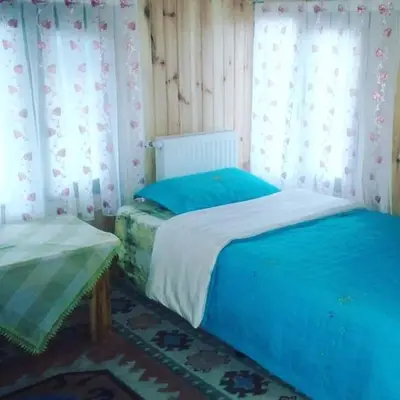 a bedroom with two beds and a window with curtains at Zirve Dağ Evi in Kocaeli
