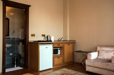 a kitchen with a white refrigerator next to a couch at Tashkonak Studio Suites in Istanbul