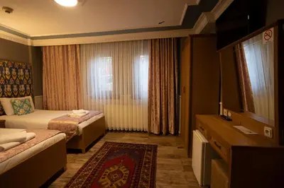 a hotel room with two beds and a television at Tashkonak Studio Suites in Istanbul