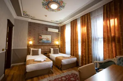 a hotel room with two beds and a table at Tashkonak Studio Suites in Istanbul