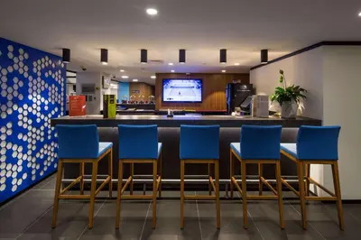 a lobby with blue chairs and a bar at Hampton by Hilton Istanbul Kurtkoy in Istanbul