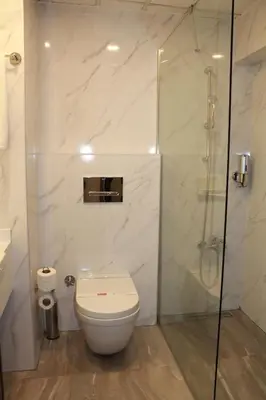 a bathroom with a toilet and a glass shower at Hotel Buyuk Sahinler in Istanbul