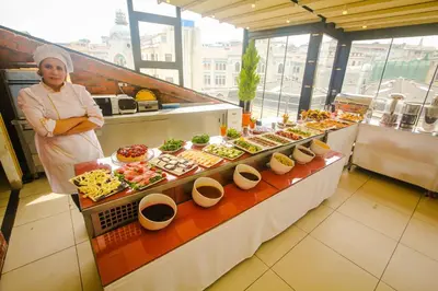 a woman standing next to a buffet of food at Venue Hotel Istanbul Old City in Istanbul