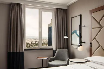 a hotel room with a chair and a window at Sheraton Istanbul Levent in Istanbul