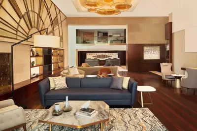 a living room with a blue couch and a fireplace at Sheraton Istanbul Levent in Istanbul