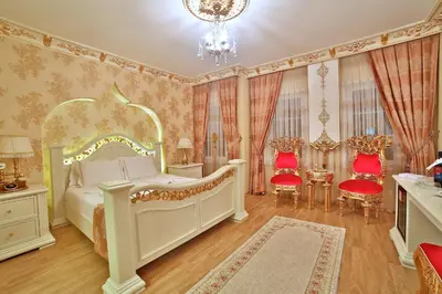 a bedroom with a bed and two chairs and a chandelier at White House Hotel Istanbul in Istanbul