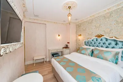 a bedroom with a large bed with a blue headboard at Hotel 1453 in Istanbul