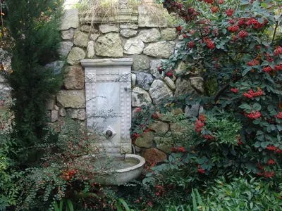 a stone wall with a bird bath in a garden at Hotel Empress Zoe in Istanbul