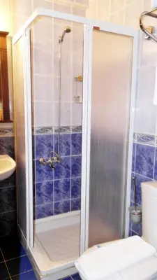 a shower in a bathroom with blue tiles at Turquhouse Hotel in Istanbul