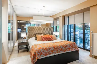 a bedroom with a bed and a desk and windows at Deger 16 Residences in Istanbul