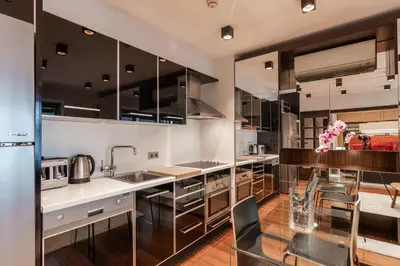 a kitchen with stainless steel appliances and a glass table at Deger 16 Residences in Istanbul