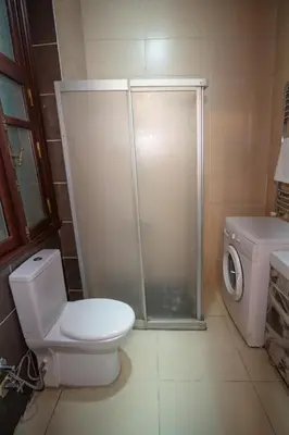 a bathroom with a toilet and a shower and a washing machine at Nest HOTEL Sisli in Istanbul