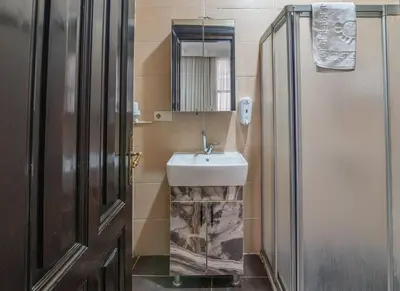 a bathroom with a sink and a mirror and a door at Nest HOTEL Sisli in Istanbul