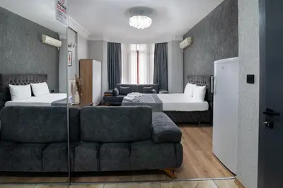 a hotel room with a couch and two beds at Nest HOTEL Sisli in Istanbul