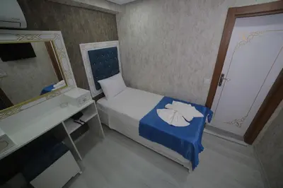 a small bedroom with a bed and a mirror at Hotel Aksaray istanbul in Istanbul