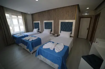 a hotel room with two beds with blue and white sheets at Hotel Aksaray istanbul in Istanbul