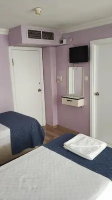 a bedroom with two beds and a tv on the wall at Hotel Akkus in Istanbul