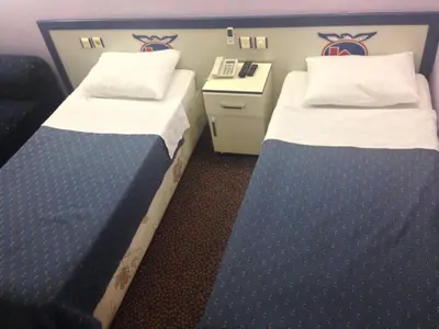 a room with two beds and a desk with at Hotel Akkus in Istanbul