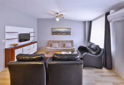 a living room with two leather chairs and a couch at Palmada Hotel in Sakarya