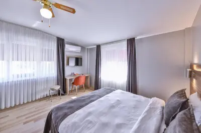 a bedroom with a bed and a desk and a window at Palmada Hotel in Sakarya