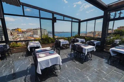 a restaurant with tables and chairs and a view of the city at Trip Bosphorus Taksim Hotel in Istanbul