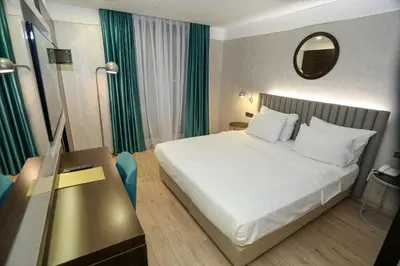 a bedroom with a bed and a table and a mirror at Milord Hotel in Istanbul