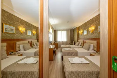 a hotel room with three beds in a room at Dalan Otel in Istanbul