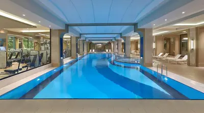 a large blue swimming pool in a hotel lobby at Elite World Grand Istanbul Basın Ekspres in Istanbul