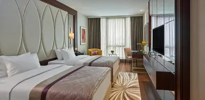 a hotel room with two beds and a television at Elite World Grand Istanbul Basın Ekspres in Istanbul