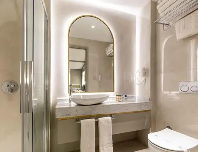 a bathroom with a sink and a toilet and a mirror at Hotel Genova Istanbul Old City in Istanbul