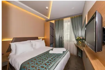 a hotel room with a bed and a flat screen tv at Hotel Genova Istanbul Old City in Istanbul