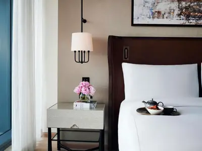 a bedroom with a bed and a table with flowers on it at Fairmont Quasar Istanbul Hotel in Istanbul
