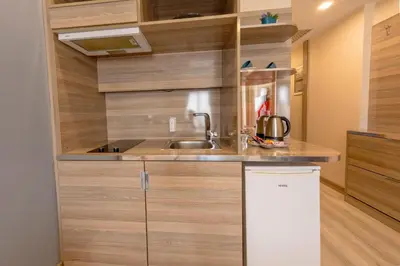a kitchen with wooden cabinets and a sink at My House N5 Suites Hotel in Esenyurt