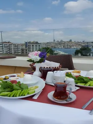 a table with plates of food and flowers on a balcony at İstasyon Hotel in Istanbul