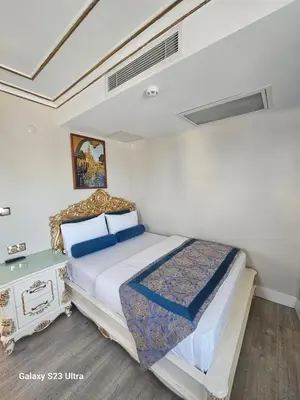 a bedroom with a large bed and a night stand at İstasyon Hotel in Istanbul