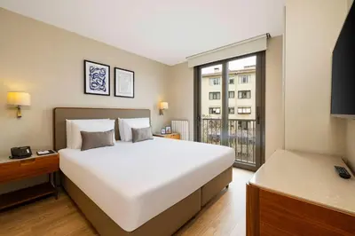 a bedroom with a large white bed and a window at Tzl Suites Hotel Nişantaşı in Istanbul