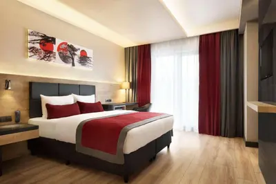 a hotel room with a large bed with red pillows at Ramada Encore by Wyndham Gebze in Gebze