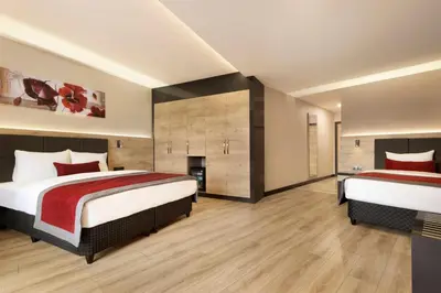 a hotel room with two beds and a fireplace at Ramada Encore by Wyndham Gebze in Gebze
