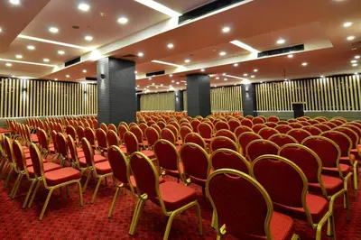 an empty cinema room with red chairs and tables at Ramada Encore by Wyndham Gebze in Gebze