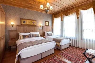 a bedroom with two beds and a chandelier at Ferman Konak Hotel-Special Category in Istanbul