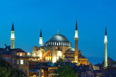 a mosque with two domes and two minarets at night at Ferman Konak Hotel-Special Category in Istanbul