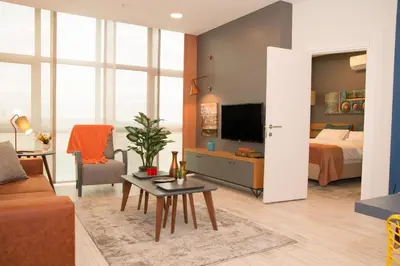 a living room with a couch and a bed and a tv at Zin D Home Dudullu Otel in Istanbul