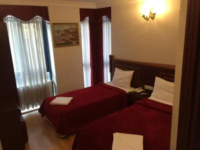 a hotel room with two beds with red sheets at Red White Hotel in Istanbul