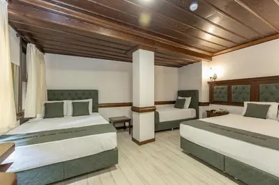 two beds in a room with wooden ceilings at Bursa Grand Family HOTEL in Bursa
