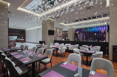 a restaurant with tables and chairs and a bar at Doubletree by Hilton Istanbul Umraniye in Istanbul