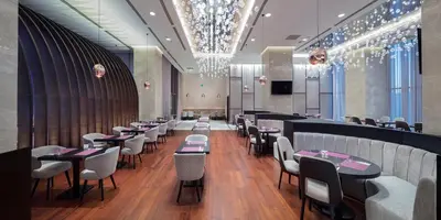 a restaurant with tables and chairs and a bar at Doubletree by Hilton Istanbul Umraniye in Istanbul