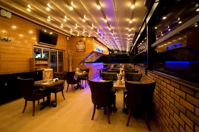 a restaurant with tables and chairs and a brick wall at Endglory Hotel in Corlu