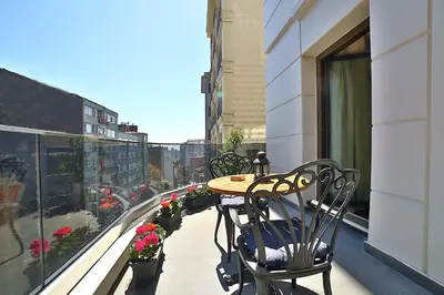 a table and chairs on a balcony with a window at Adelmar Hotel Istanbul Sisli in Istanbul