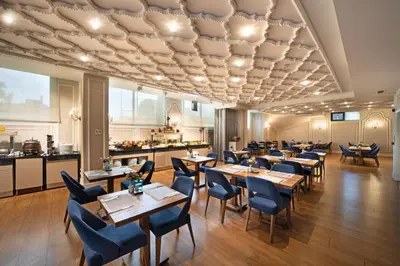 a restaurant with wooden tables and chairs and a kitchen at The Time Hotel Marina in Istanbul