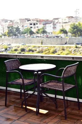 a table and chairs on a balcony with a view at Hande Hotel in Mustafakemalpaşa